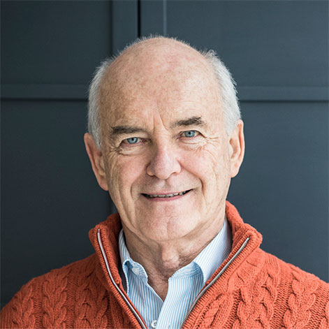 Portrait of an older professional man with an orange cable-knit sweater