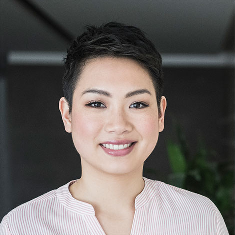 Portrait of a professional woman with a pixie cut and pink striped shirt