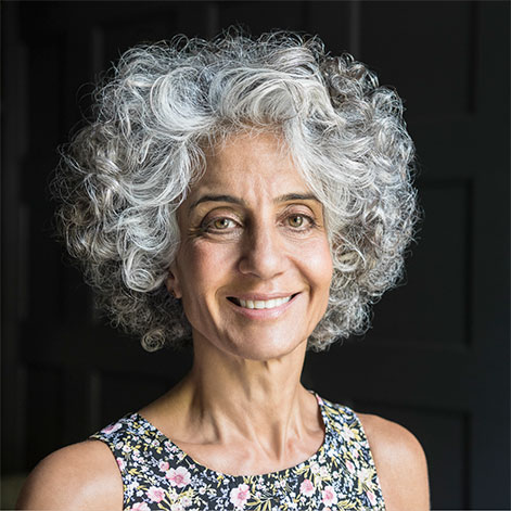 Portrait of an older woman with gray curly hair and a floral top