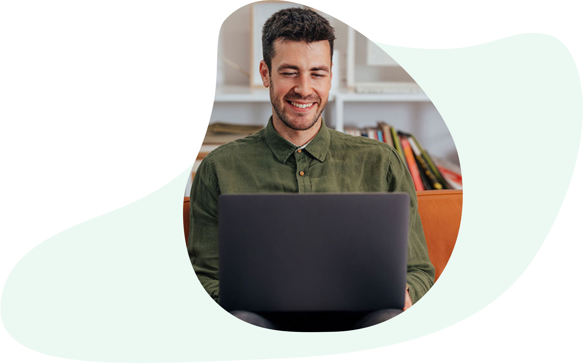 Man wearing a green shirt and working on his laptop